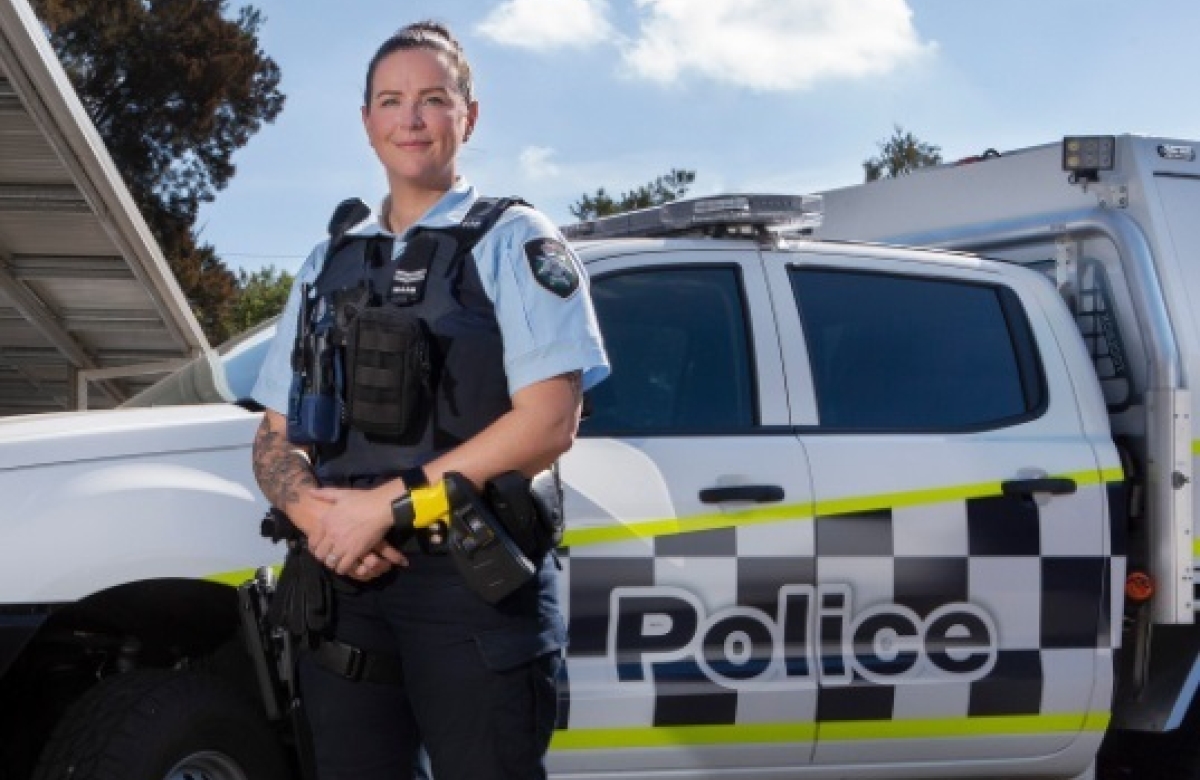 ACT Police officer standing in front of a marked police vehicle